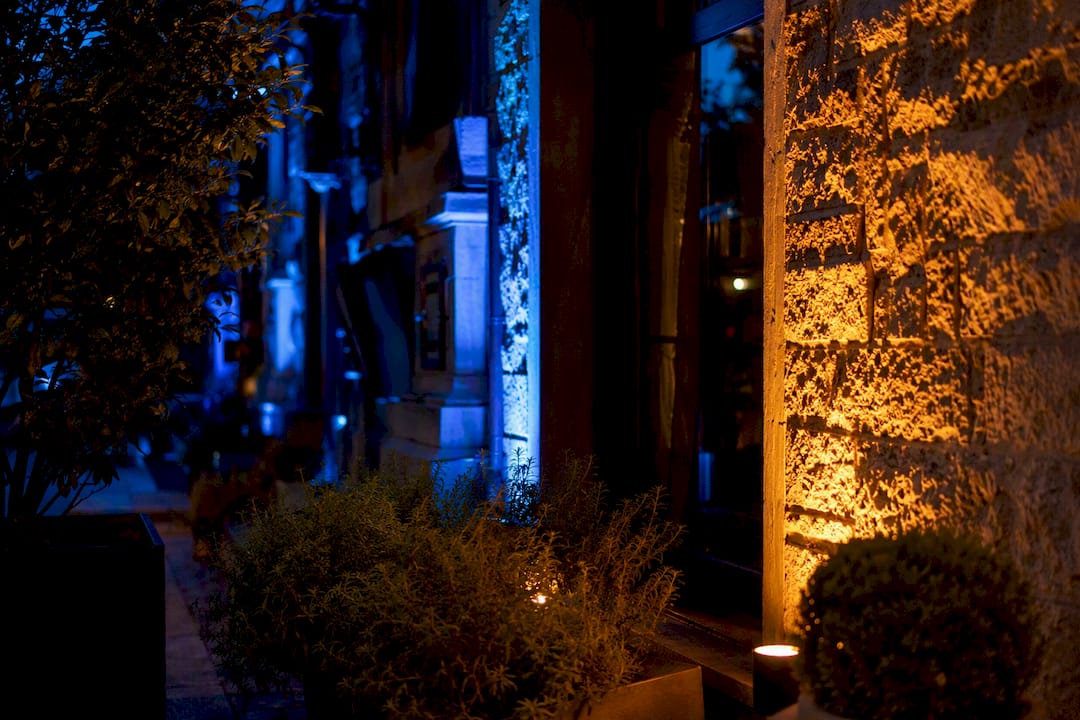 Seasonal color-changing LED uplighting on patio facade