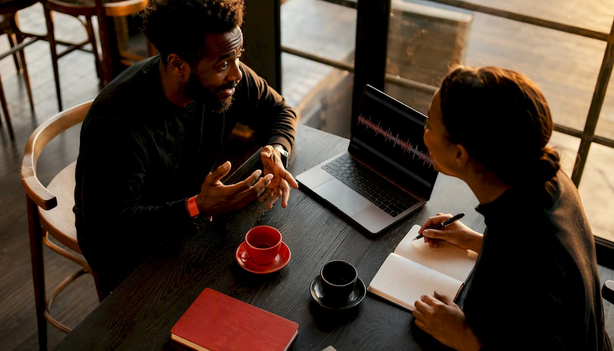 Man discussing transcript generation workflow with peer
