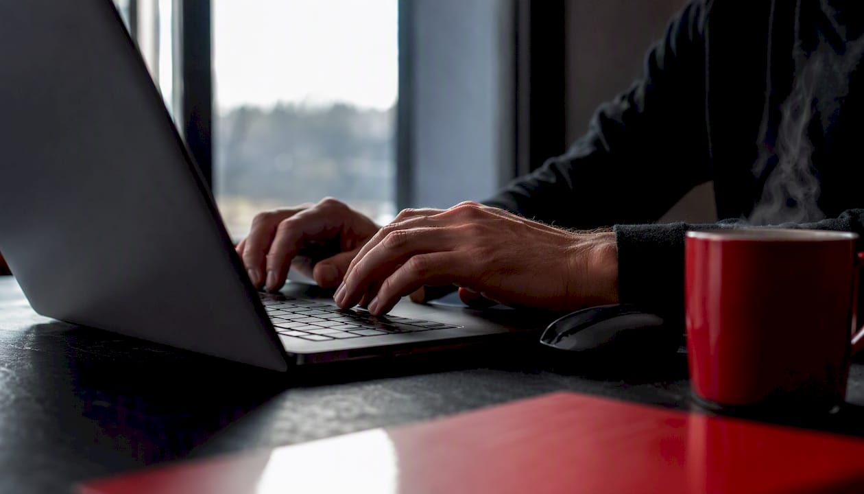 Hands activating Chrome extension on laptop