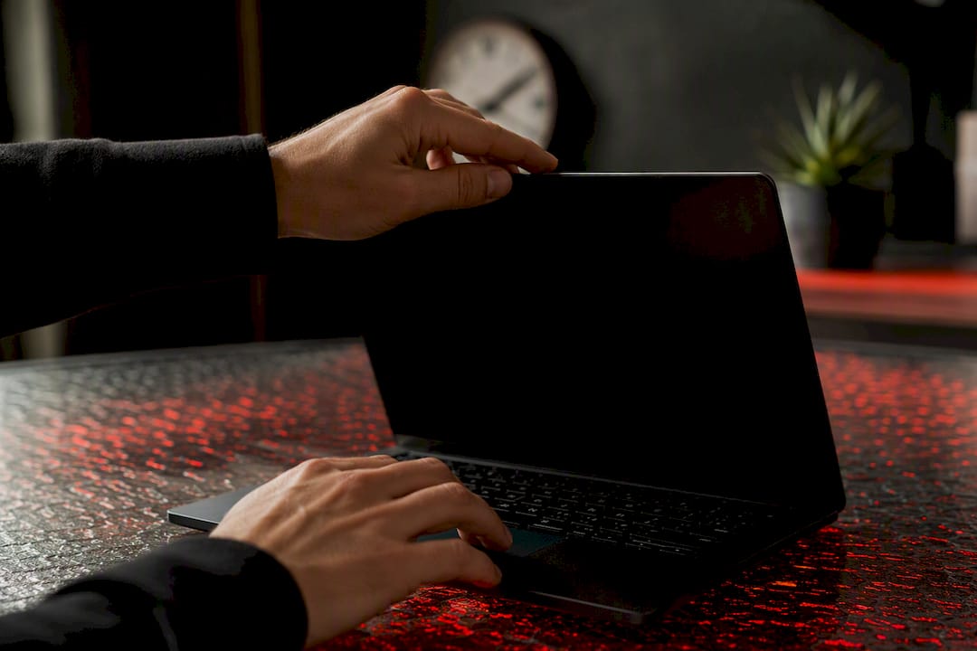 Hands opening extension panel on laptop