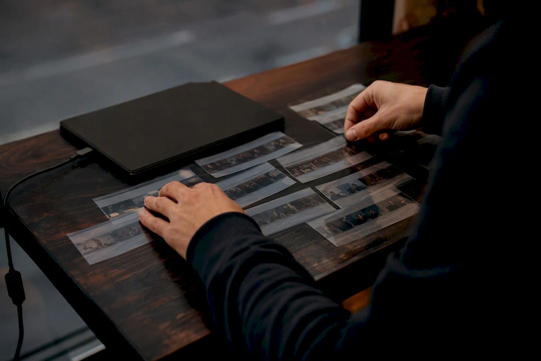 Hands organizing video timestamp overlays on black table