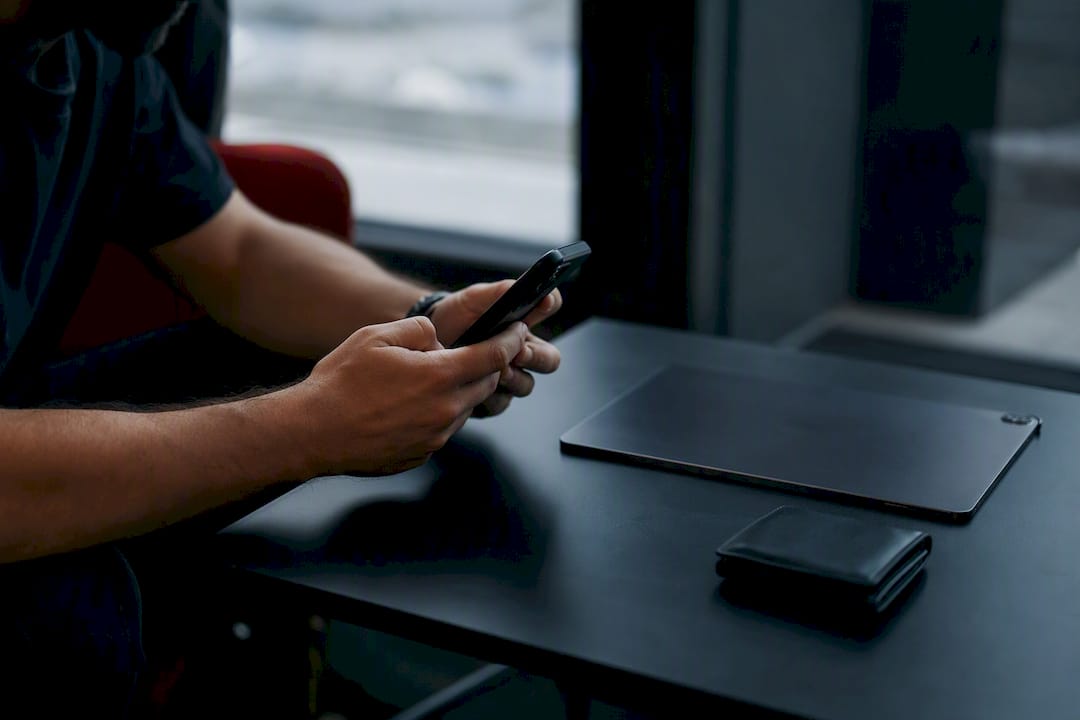Hands holding smartphone over modern desk