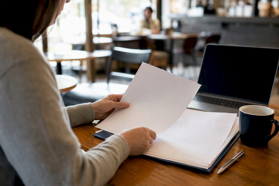 Hands organizing financial documents on desk