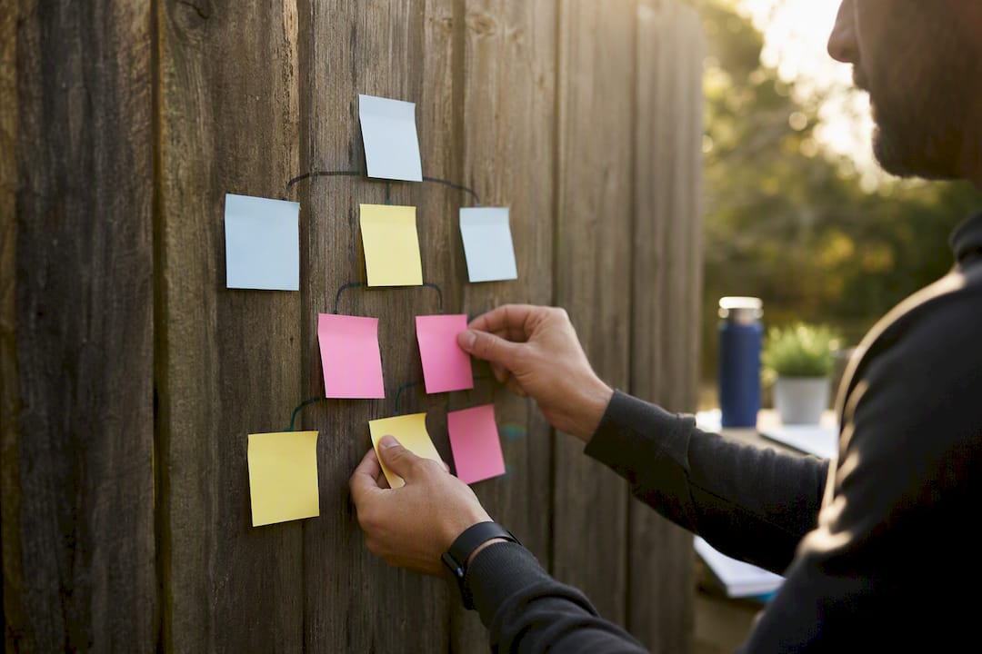 Hands arranging sticky notes for decision mapping