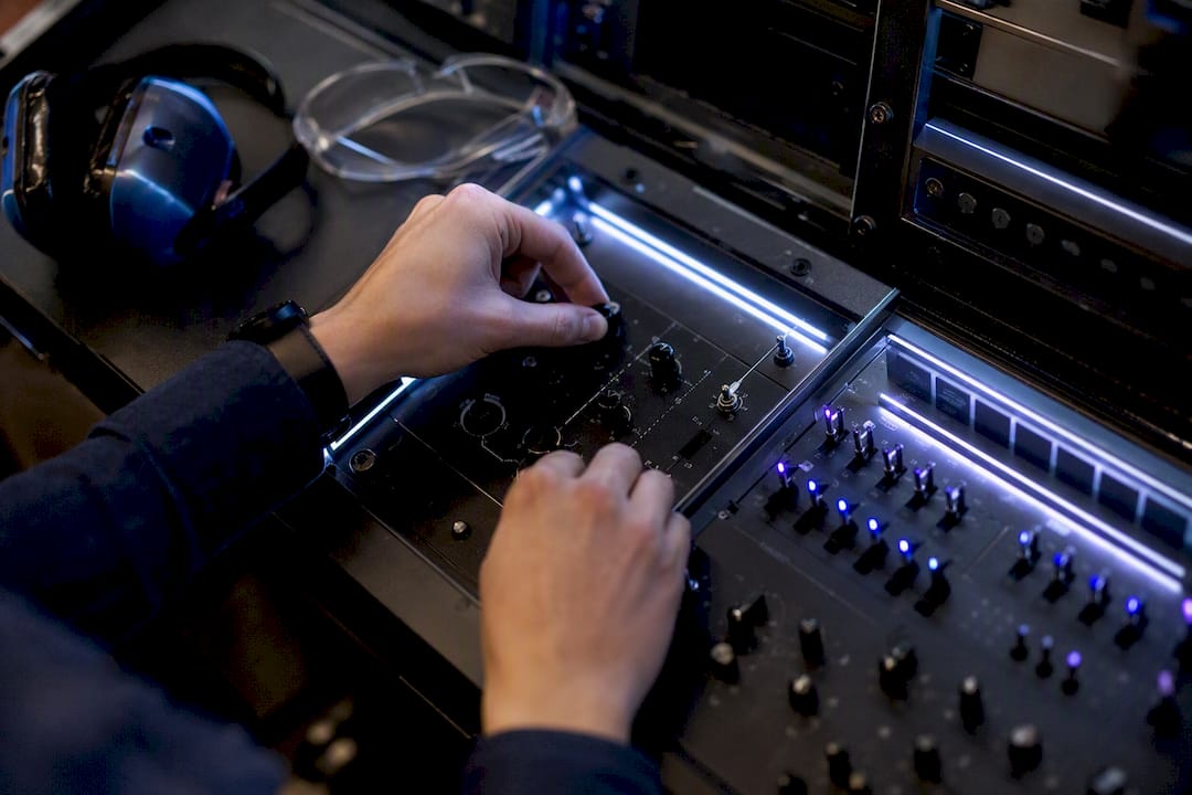 Hands performing manual oversight on AI system controls