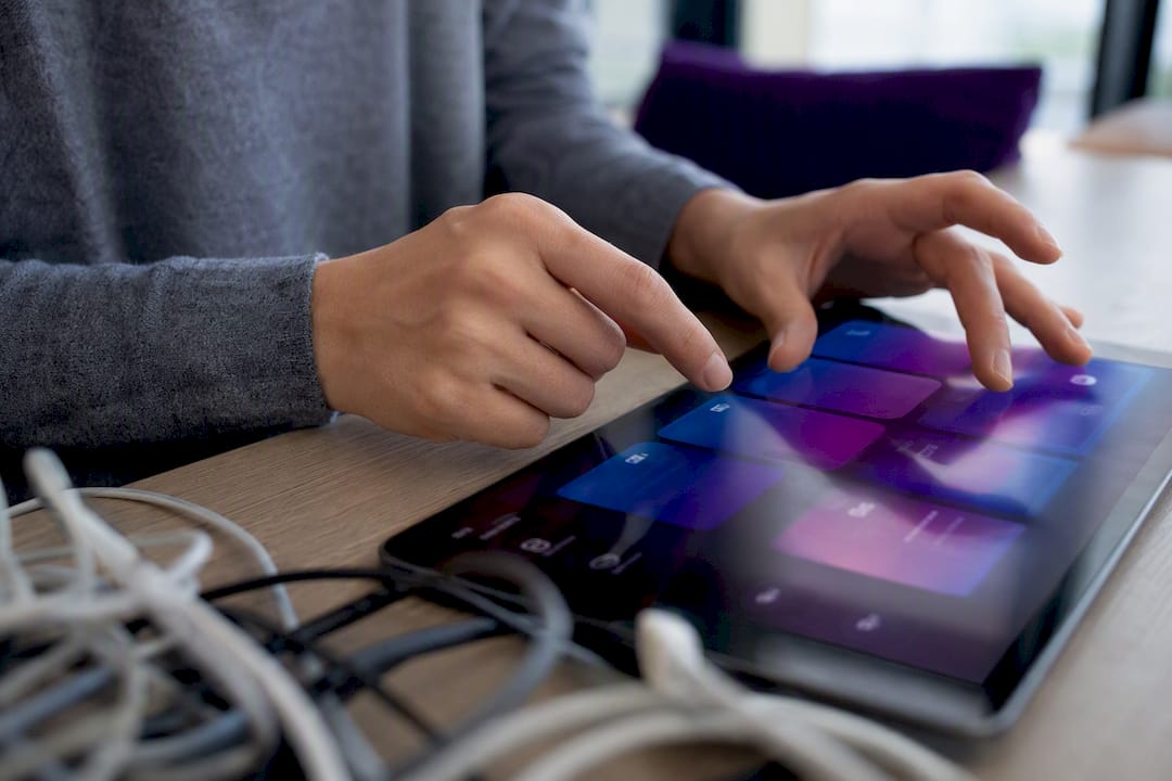 Hands browsing learning content on touchscreen device