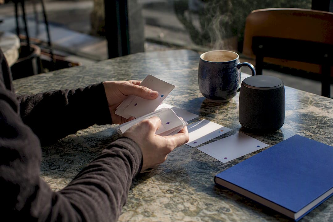 Hands scanning workflow cards on table