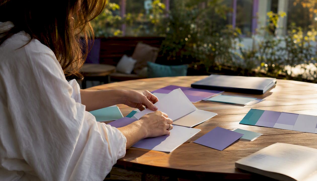 Hands near product mockups on designer table