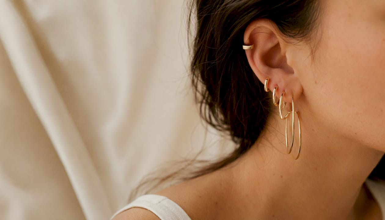 Ear with stacked hoop earrings of various sizes