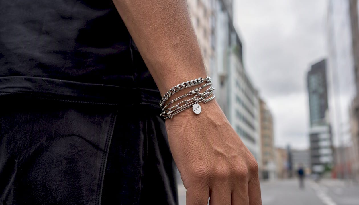Muñeca adornada con varias pulseras en un ambiente urbano.