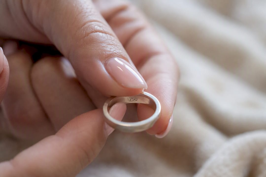 Revisando a mano el sello distintivo en un anillo de plata