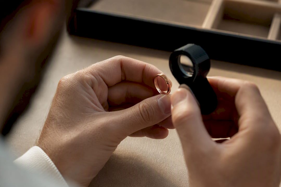 Hands examining maker marks on a ring