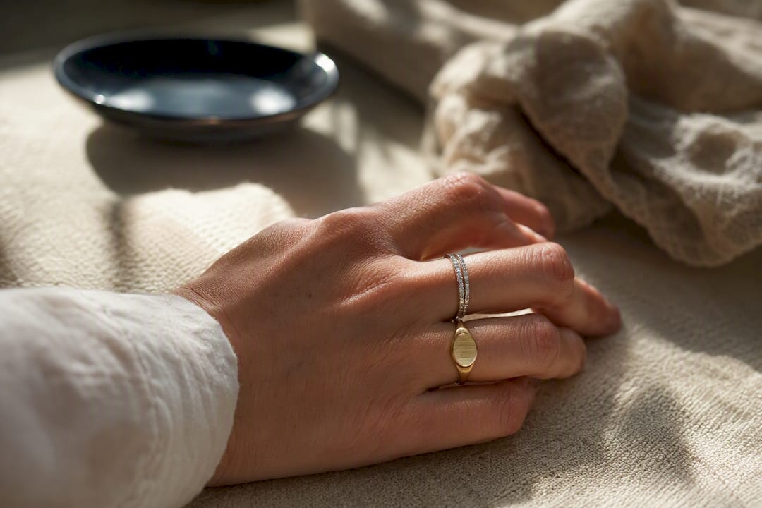 Yellow gold signet ring flanked by white gold bands