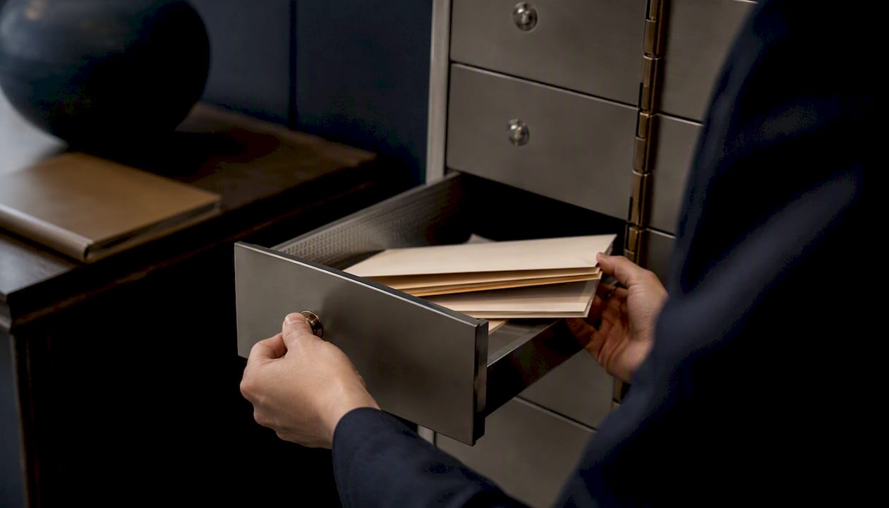 Hands opening safe deposit box drawer