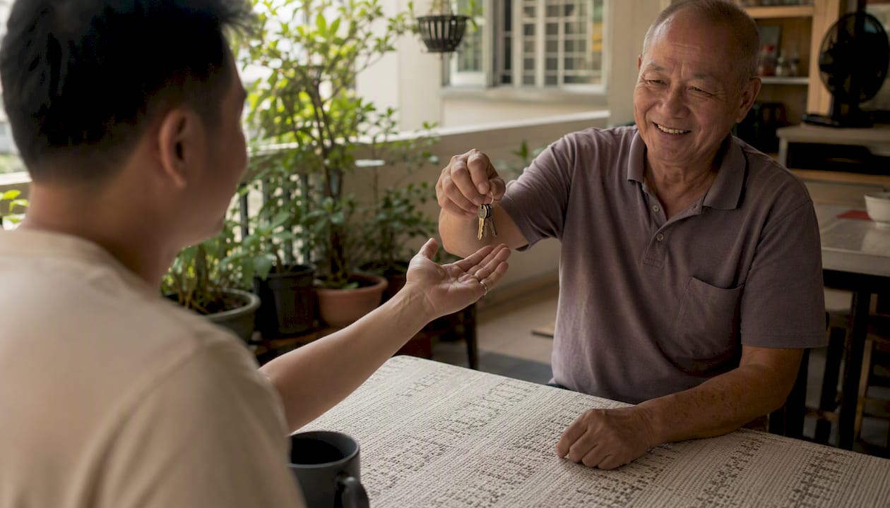 Hands exchanging keys in HDB flat living room