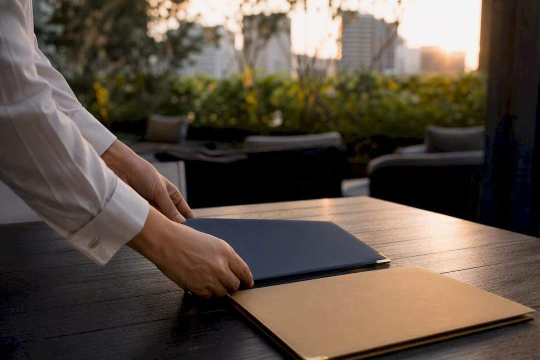 Hands placing trust deed on wood table