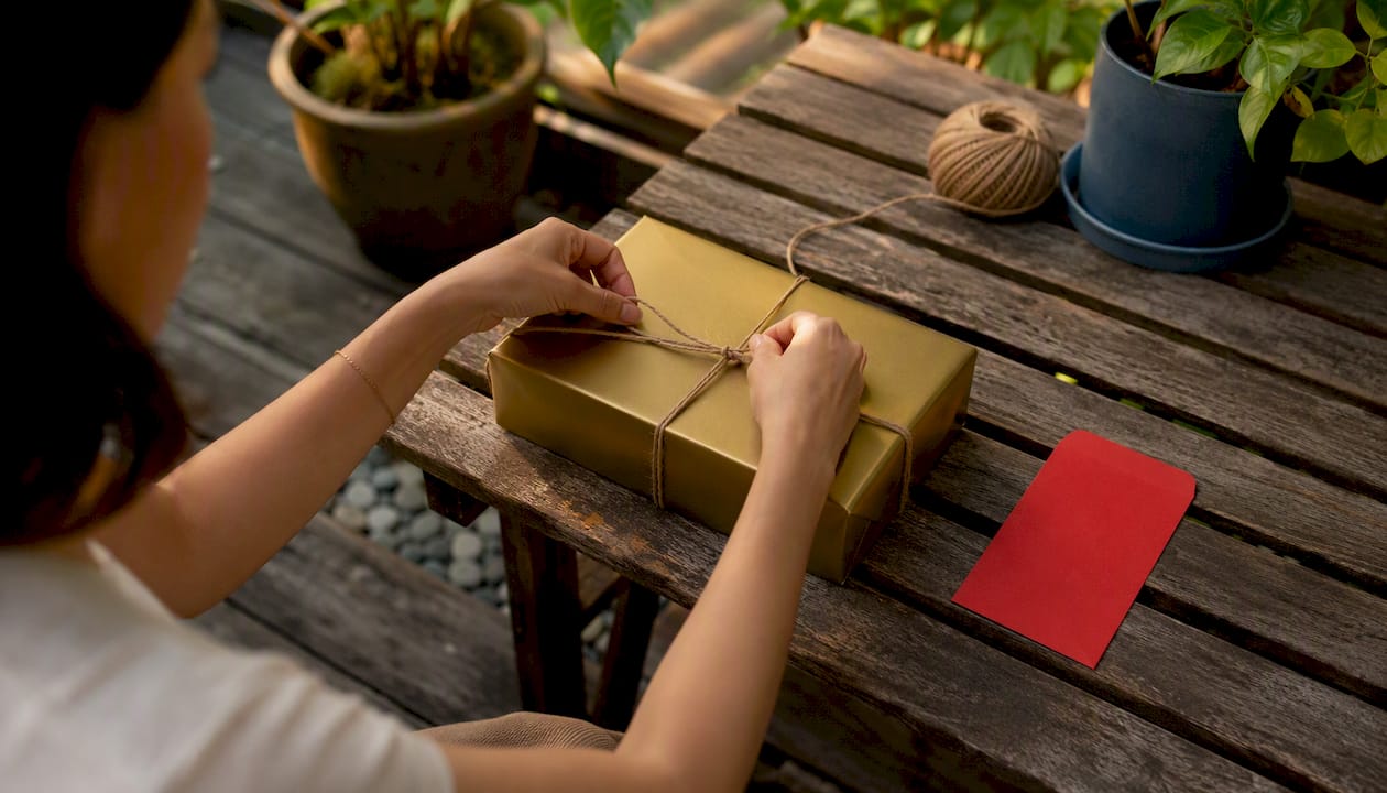 Hands wrapping festive gift box