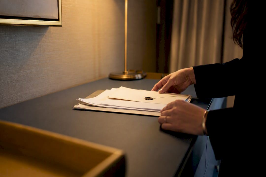 Hands arranging trust documents on elegant desk