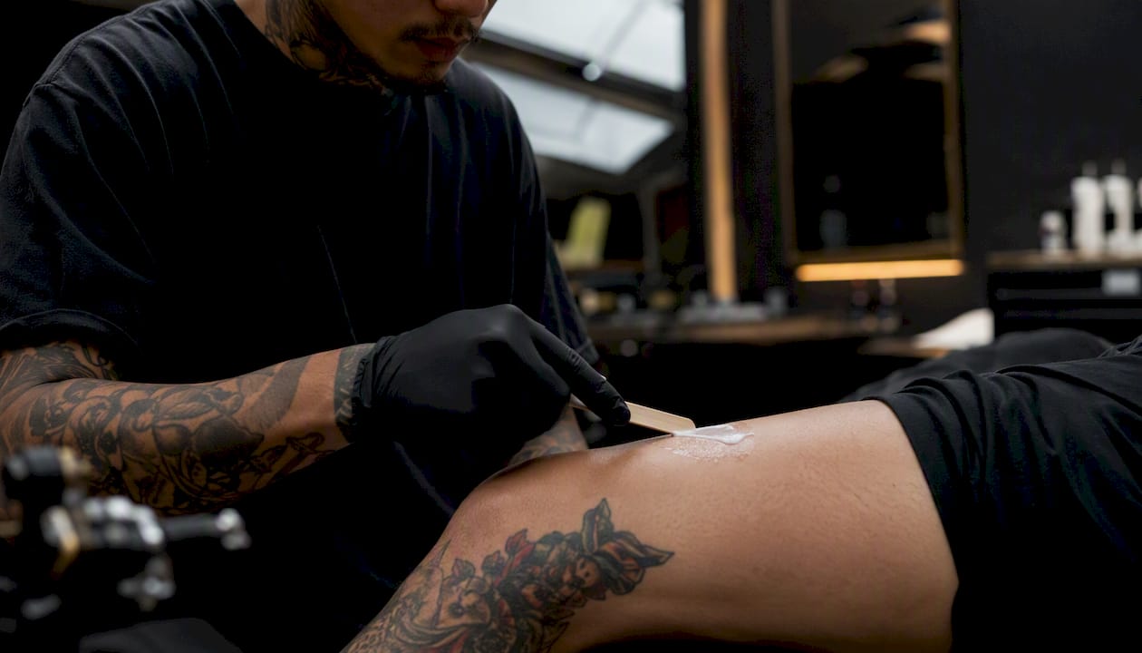 Hand applying numbing cream with applicator on arm
