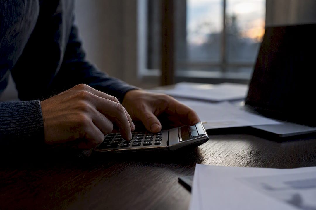 Hands using calculator for interest rates