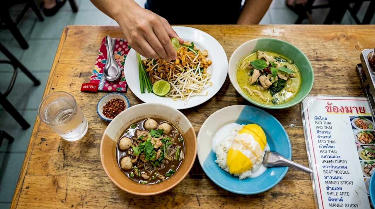 Assorted Thai dishes on wooden table