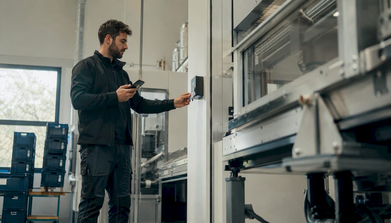 Tecnico che registra l’ingresso al lavoro utilizzando badge e smartphone