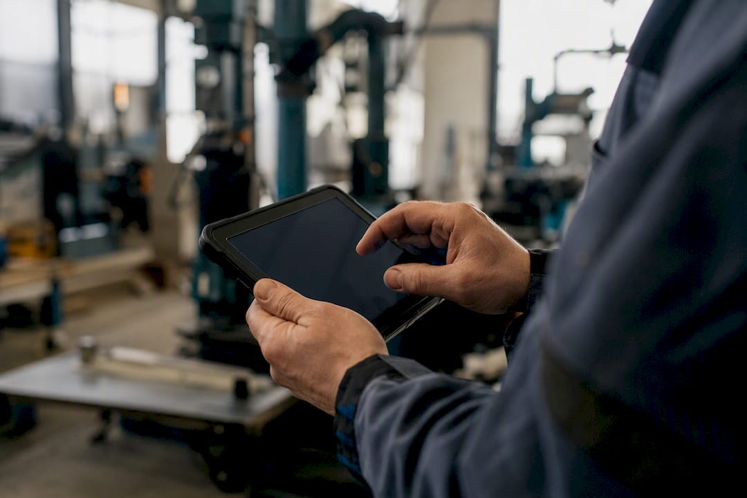 Mani di un tecnico di manutenzione che utilizzano uno strumento digitale