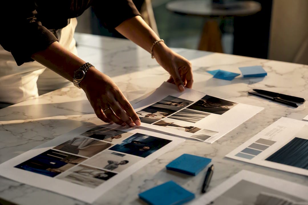 Hands arranging annotated moodboard sheets