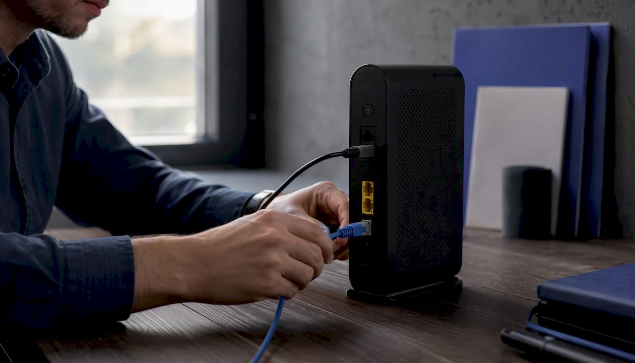 Hands plugging network cable on desk
