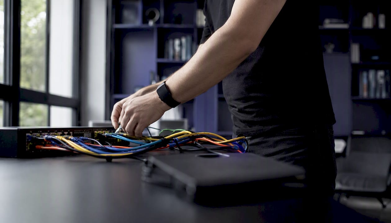 Hands unplugging a network cable from router