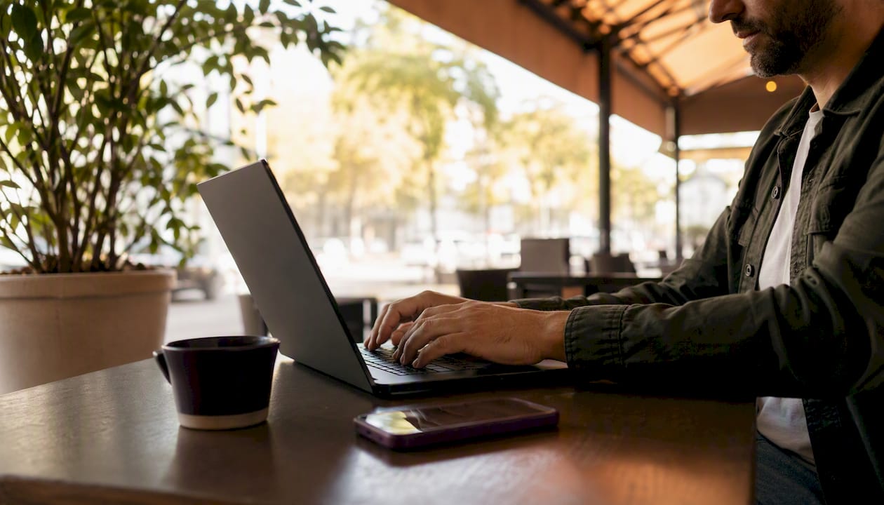Hands typing business info on laptop