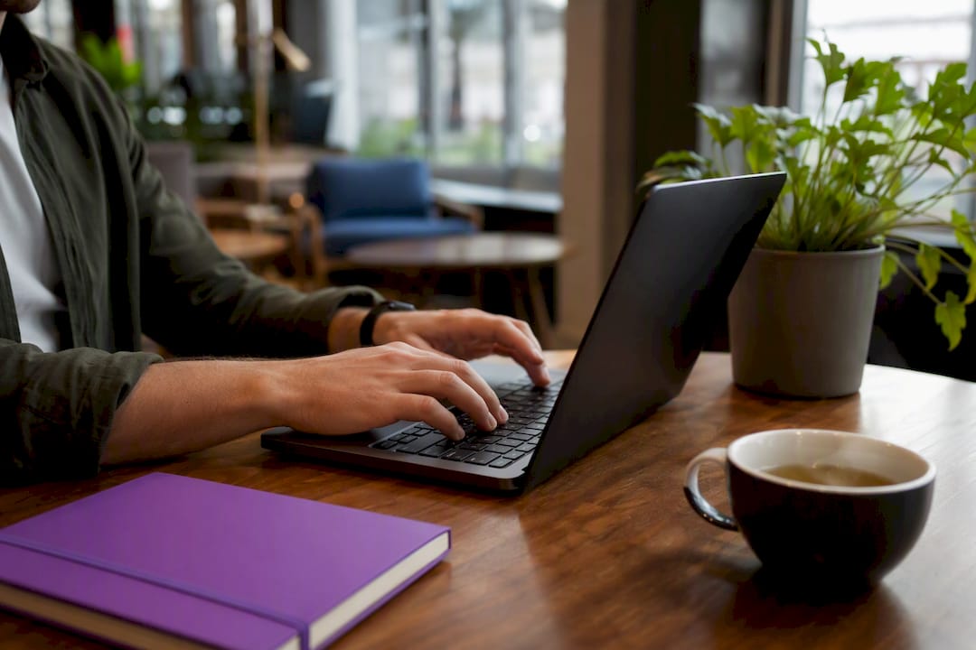 Hands tagging URLs on laptop in office