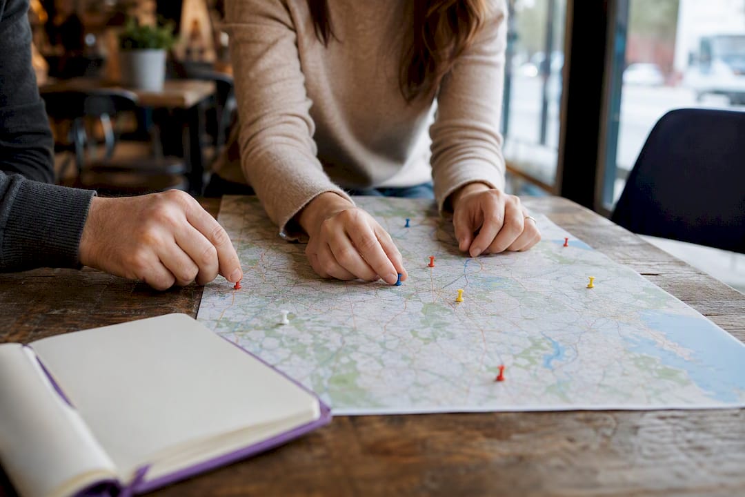 Hands grouping pins on map for multi-location SEO