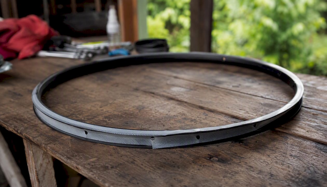 Wide bike rim with overlapping tubeless tape strips