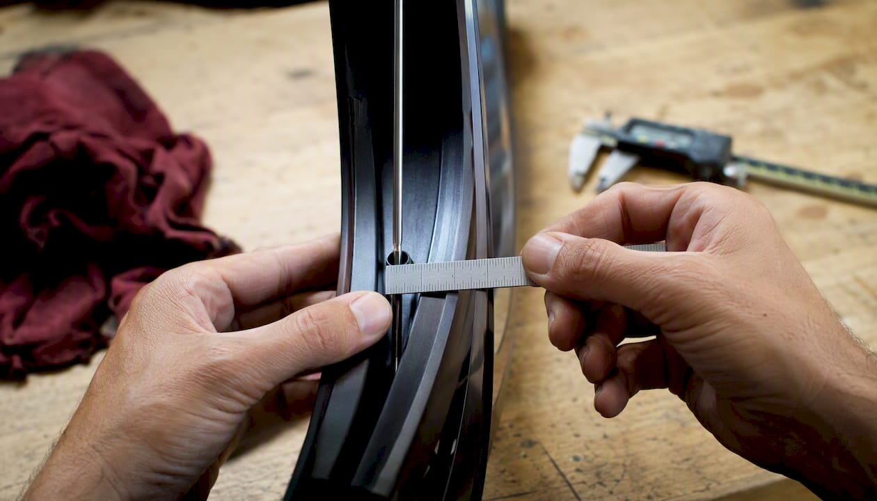 Hands measuring rim depth with ruler