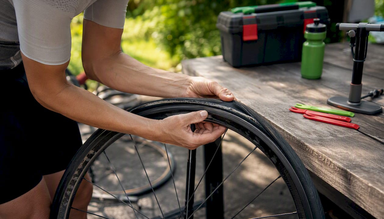 Hands mounting directional cycling tire on rim