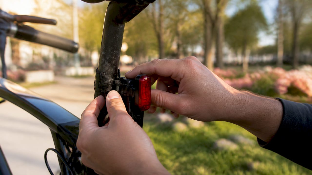 Hands mounting rear bike light on seatpost