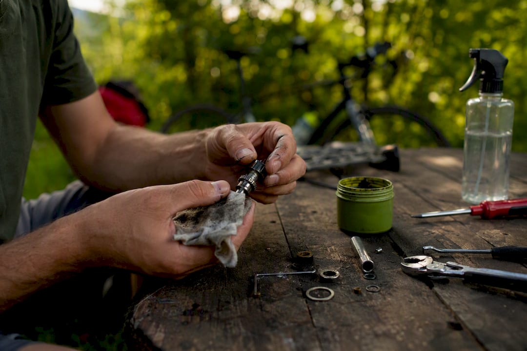 Hands servicing SPD pedal axle outdoors