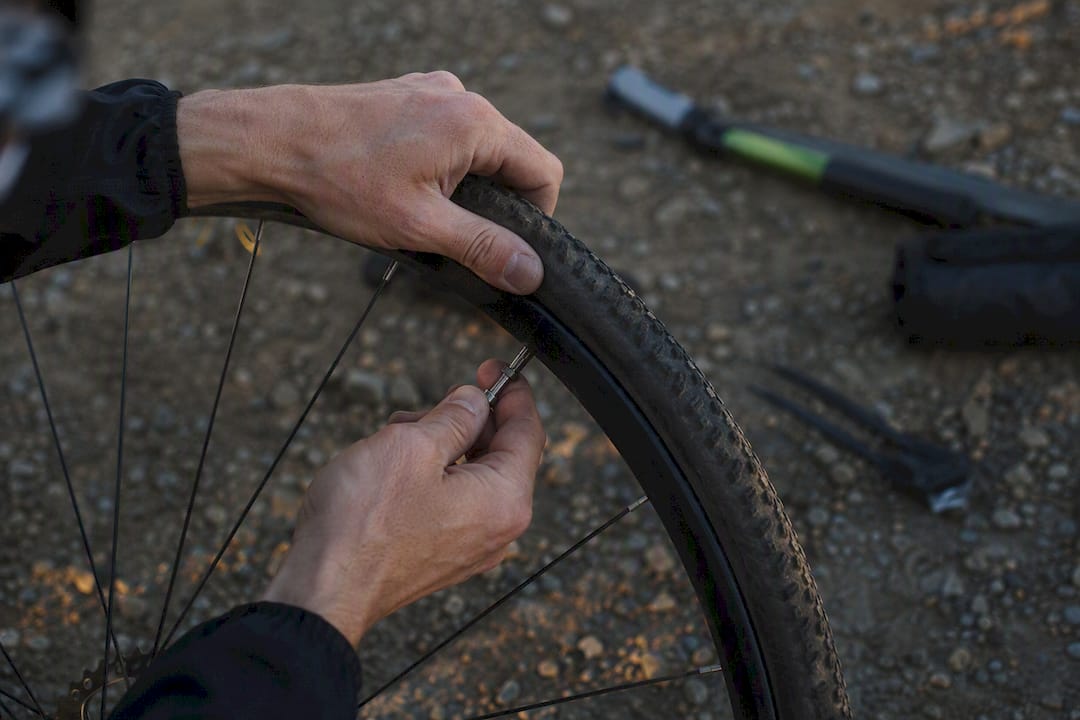 Hands removing front gravel tire from rim