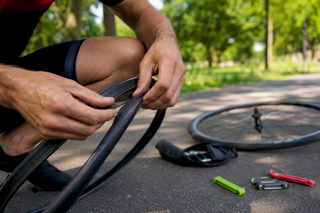 Triathlete hands changing bike tube outdoors