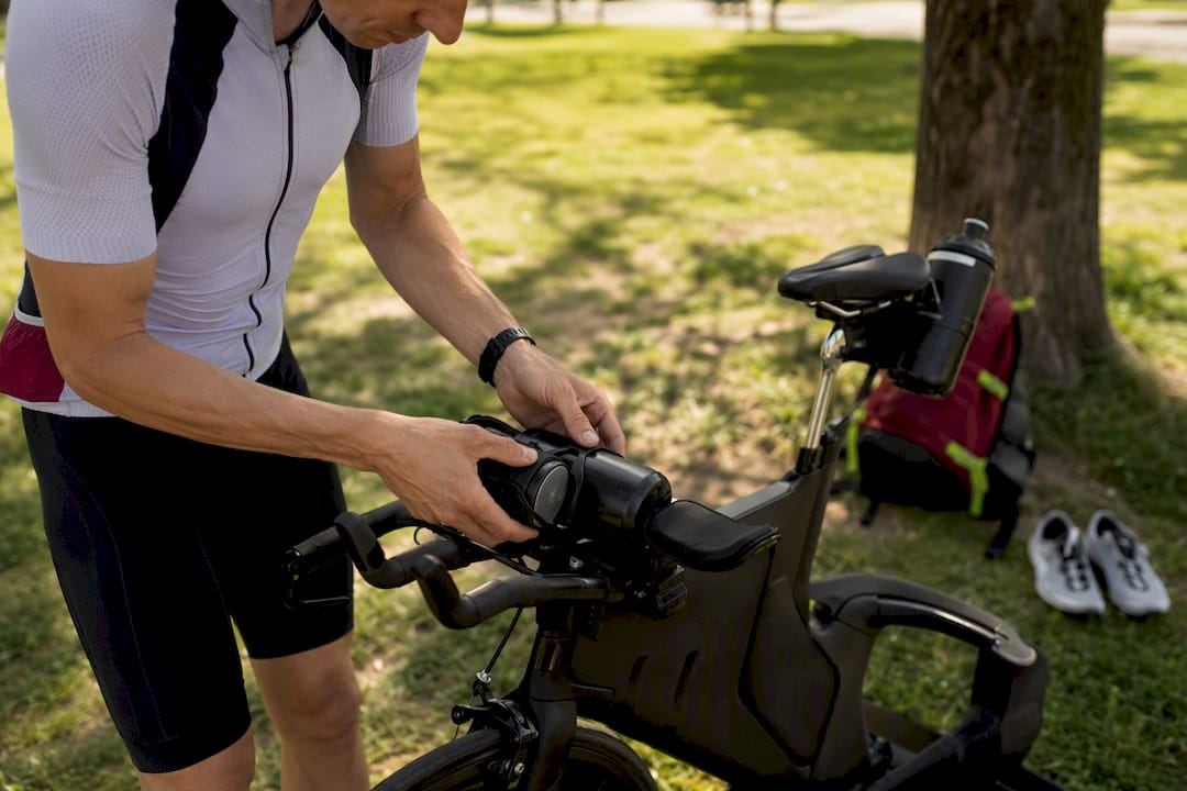Hands mounting hydration bottles on triathlon bike