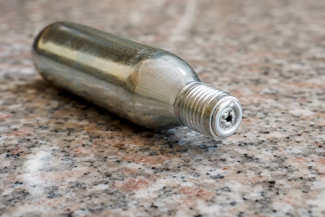 Close-up of empty CO2 cartridge with punctured seal