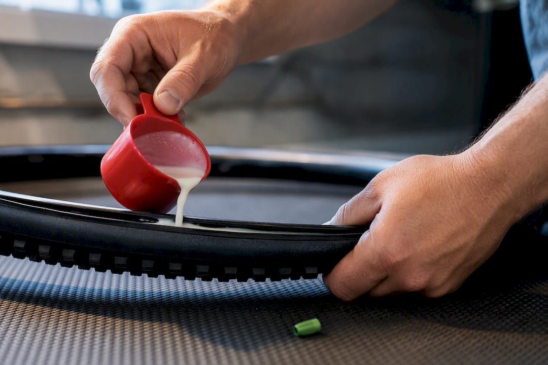 Mechanic adding sealant to tubeless tire