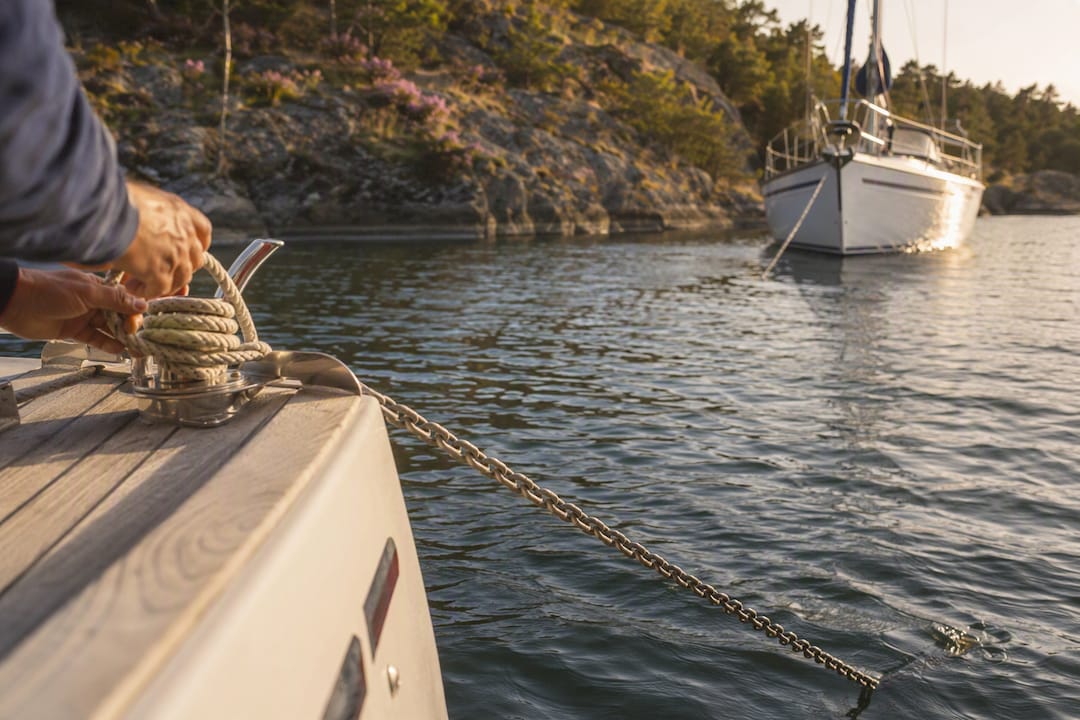 Sailboat deploying stern anchor at channel anchorage