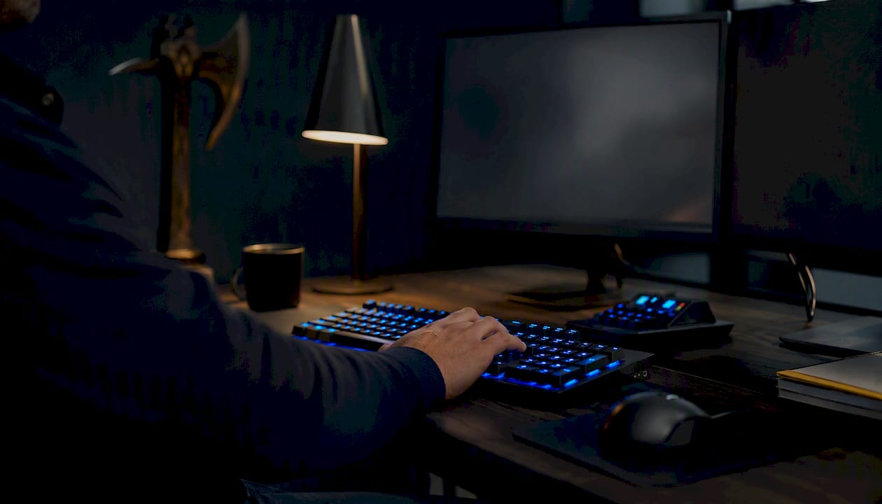 Trader adjusting keyboard at dark trading desk