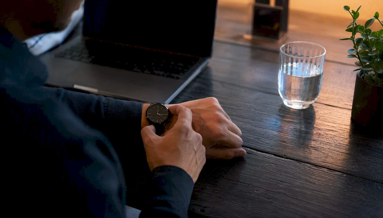 Trader adjusting wristwatch for weekend holding