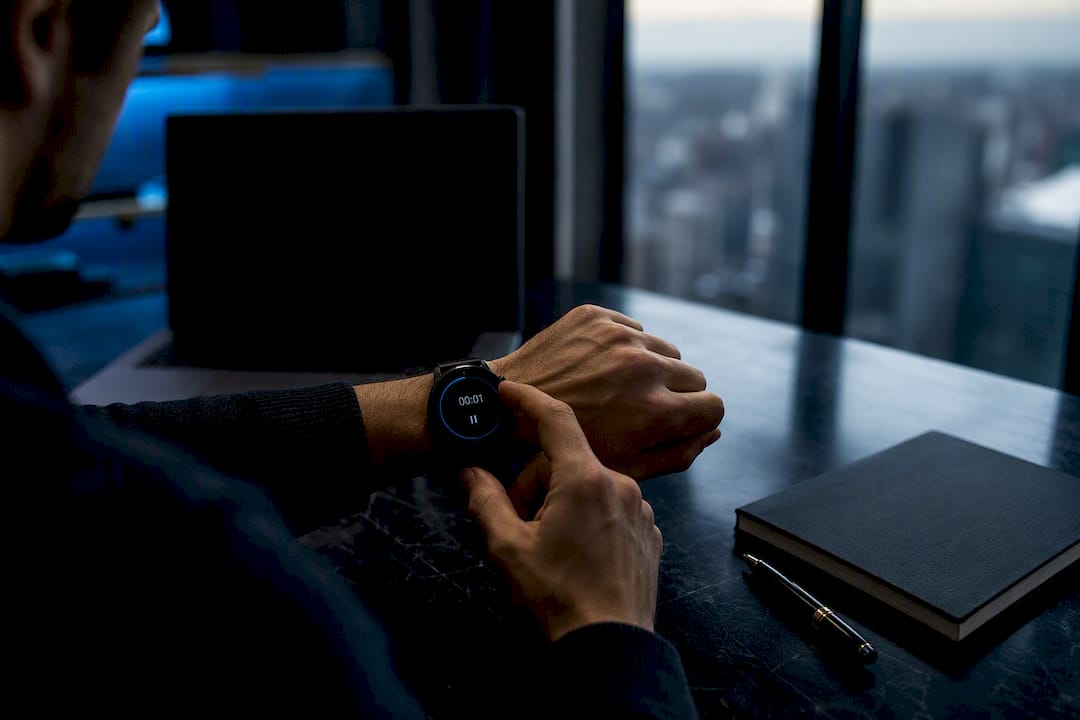 Hands pausing timer on wristwatch