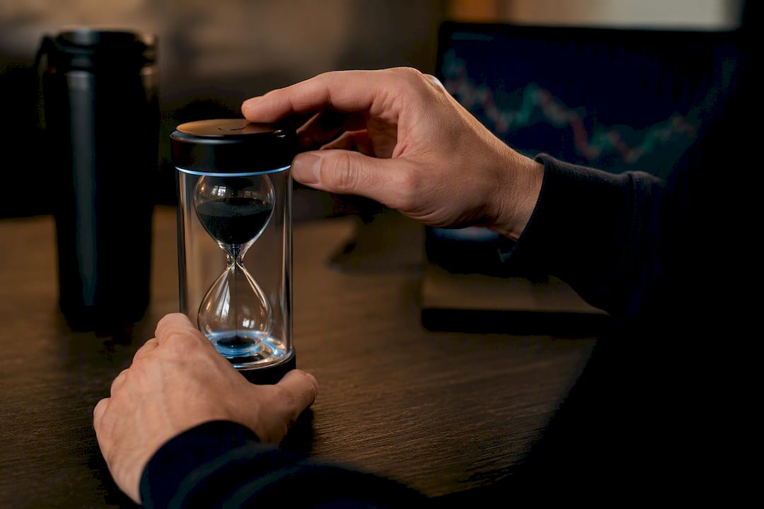 Hands resetting a digital hourglass timer