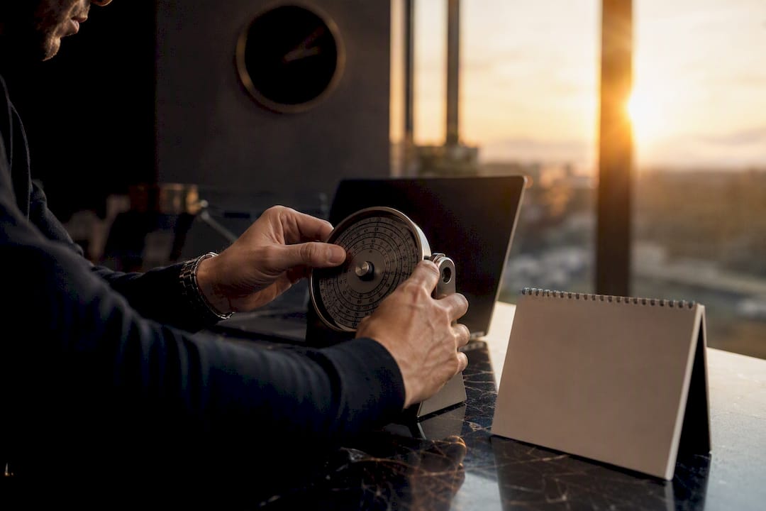 Trader's hands adjusting wristwatch and pen