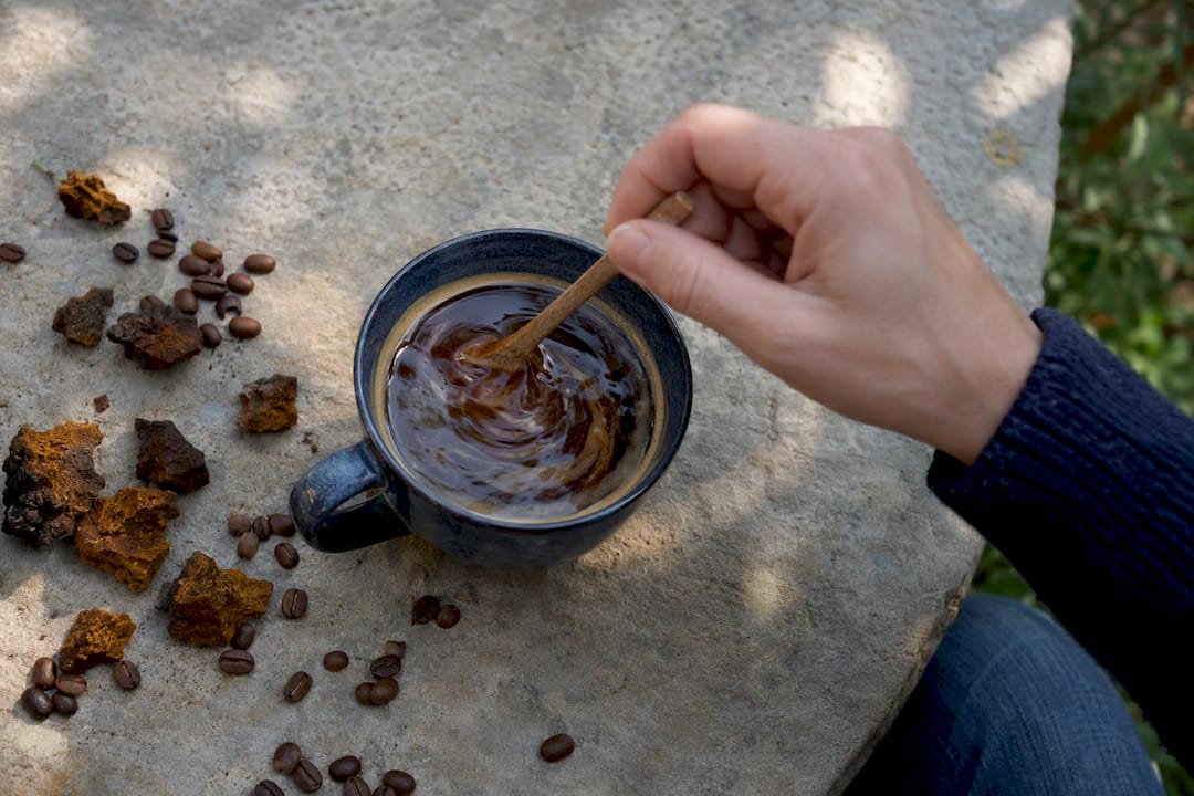 Hand stirring dual-extract chaga into coffee